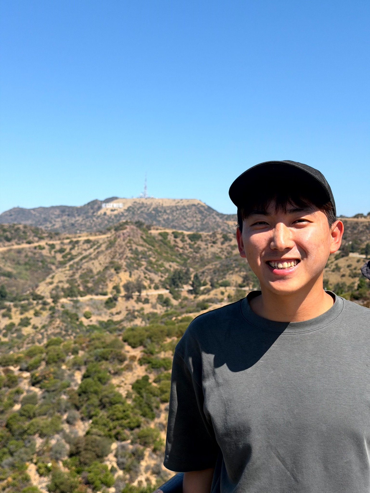 Yu-Kai on a sunny trail with hills in the background